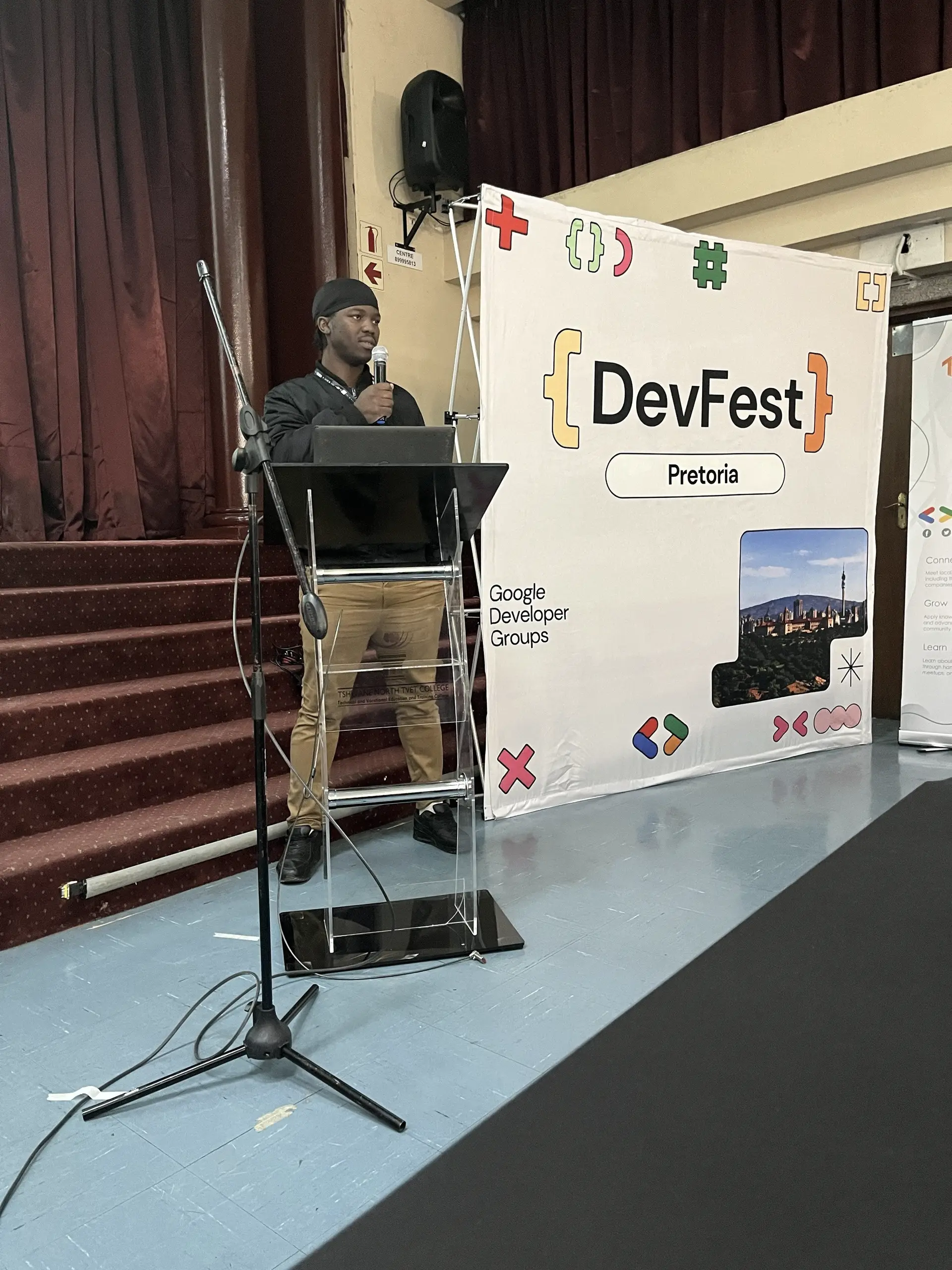 A FORGE member at the podium beside the GDG DevFest Pretoria banner.